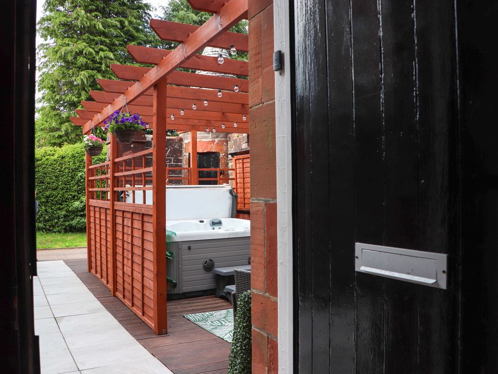 An outdoor area with a hot tub and wooden structure at Rob Roy Apartment in Buchlyvie
