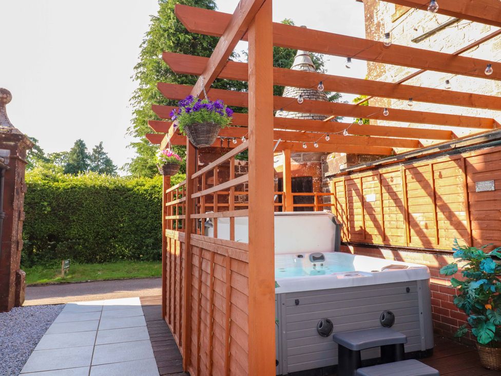 An outdoor area featuring a hot tub and wooden pergola at Rob Roy Apartment in Buchlyvie
