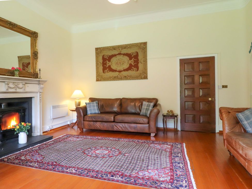 A living room with a fireplace and sofa at Rob Roy Apartment in Buchlyvie