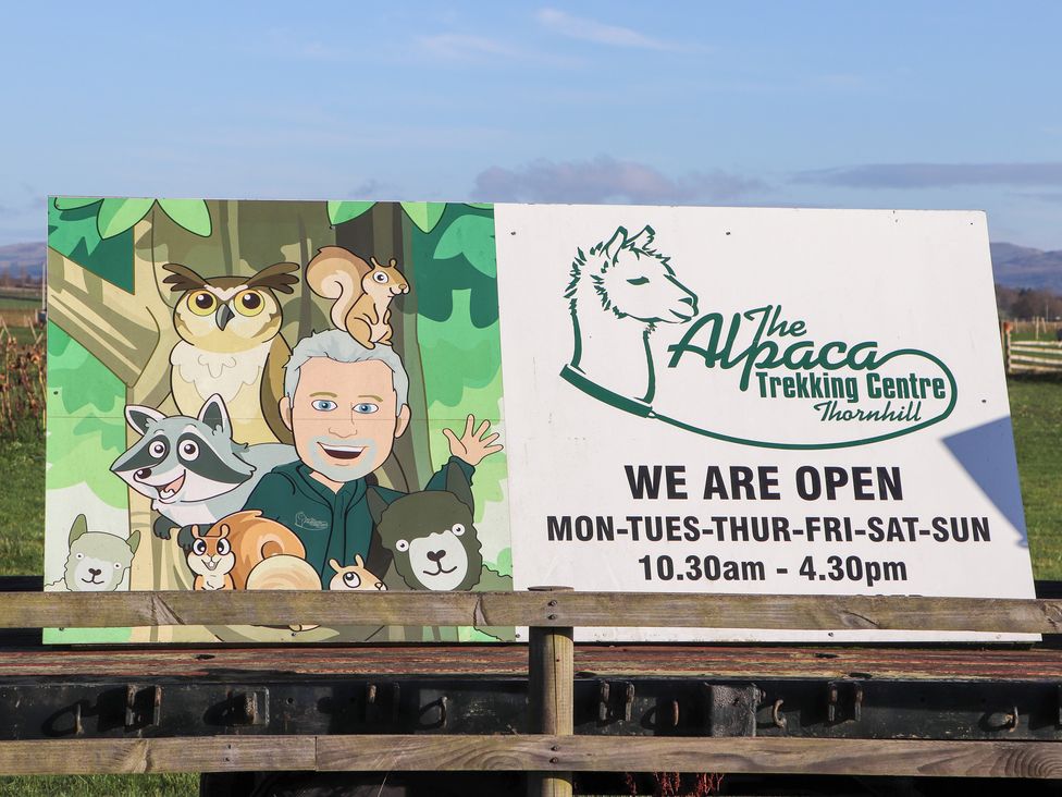 A sign with cartoon animals and opening hours at The Alpaca Trekking Centre Thornhill