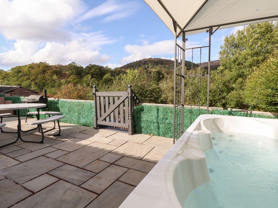 An outdoor area with a hot tub and patio furniture at Castellolwg