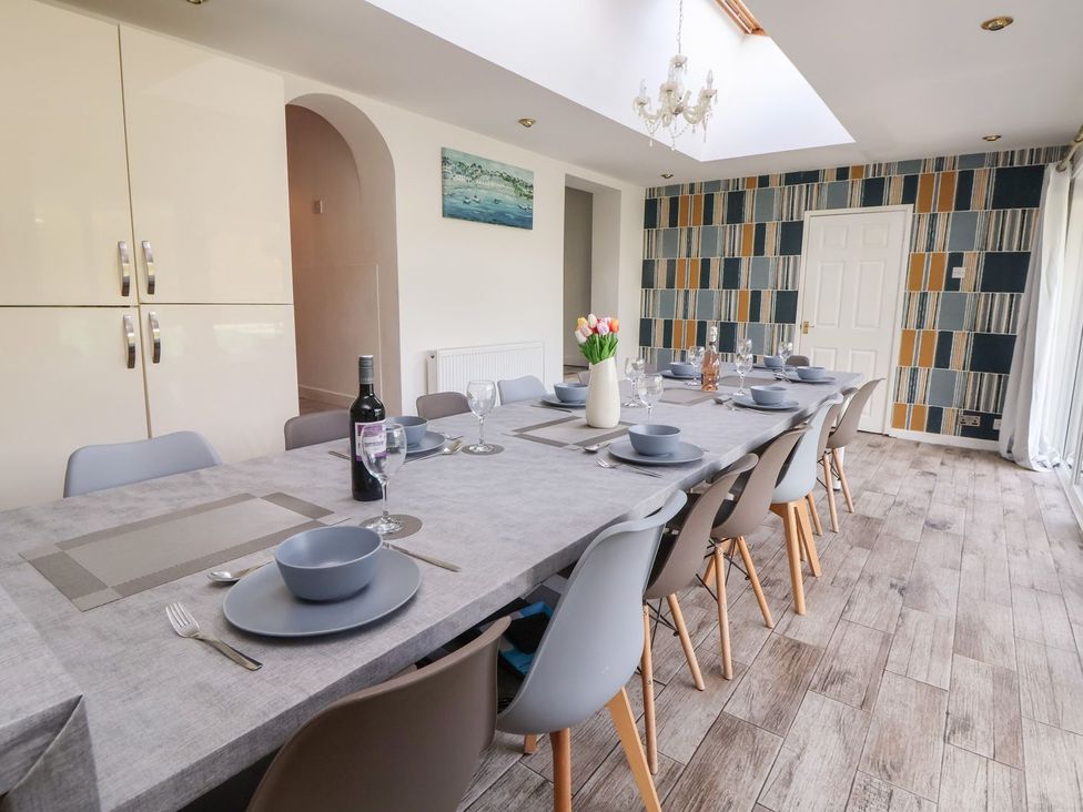 A dining room with a long table set for a meal at Castellolwg