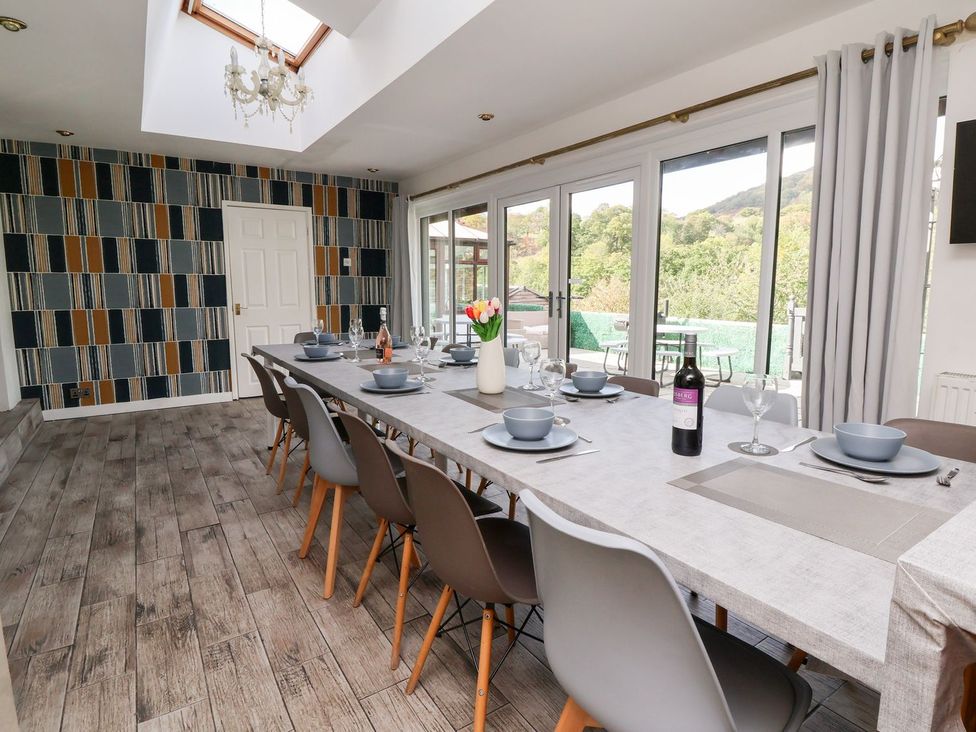 A dining room with a long table and chairs at Castellolwg