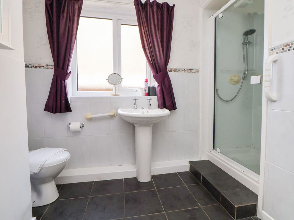 A bathroom with a sink, toilet and shower at Castellolwg