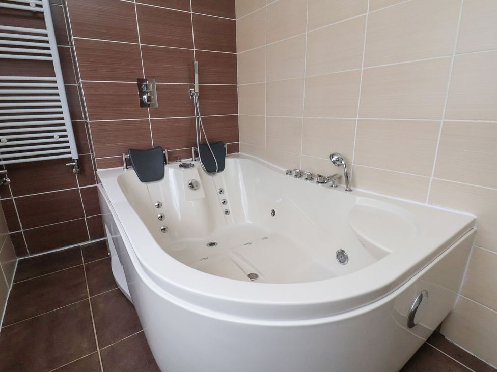 A bathroom with a bathtub and showerhead at Castellolwg