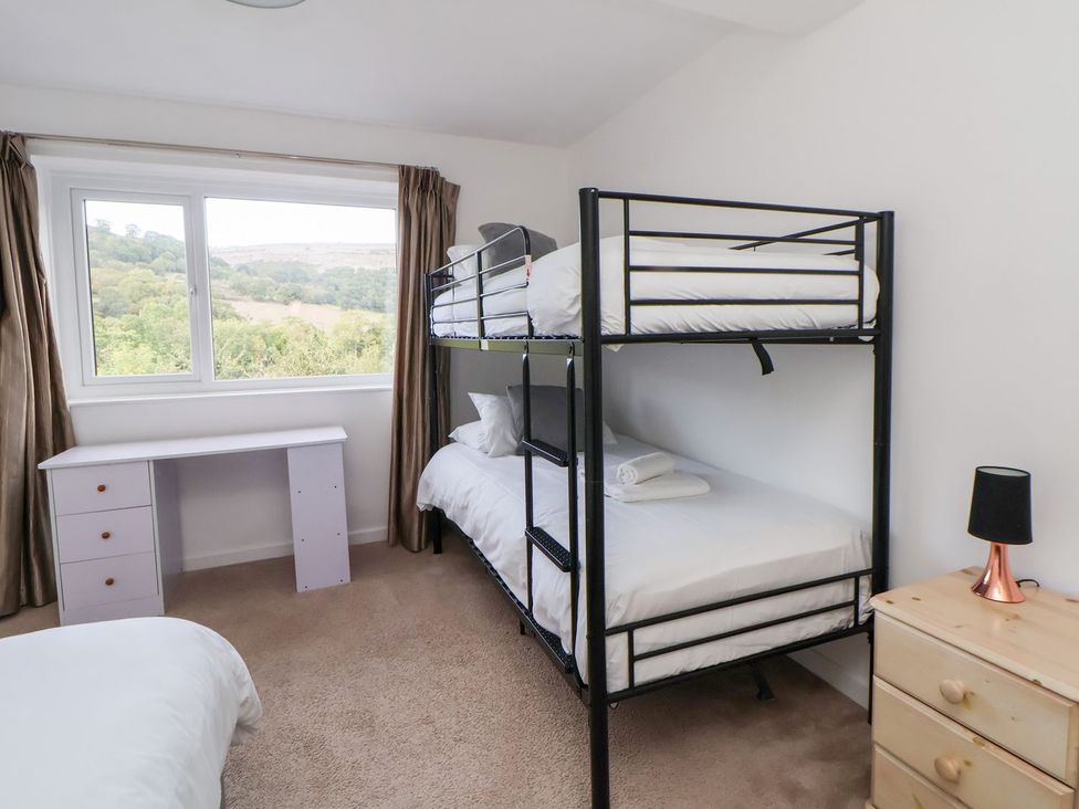 A bedroom with a bunk bed and a desk at Castellolwg 