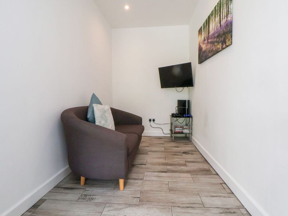 A living room with a sofa and a television at Castellolwg 