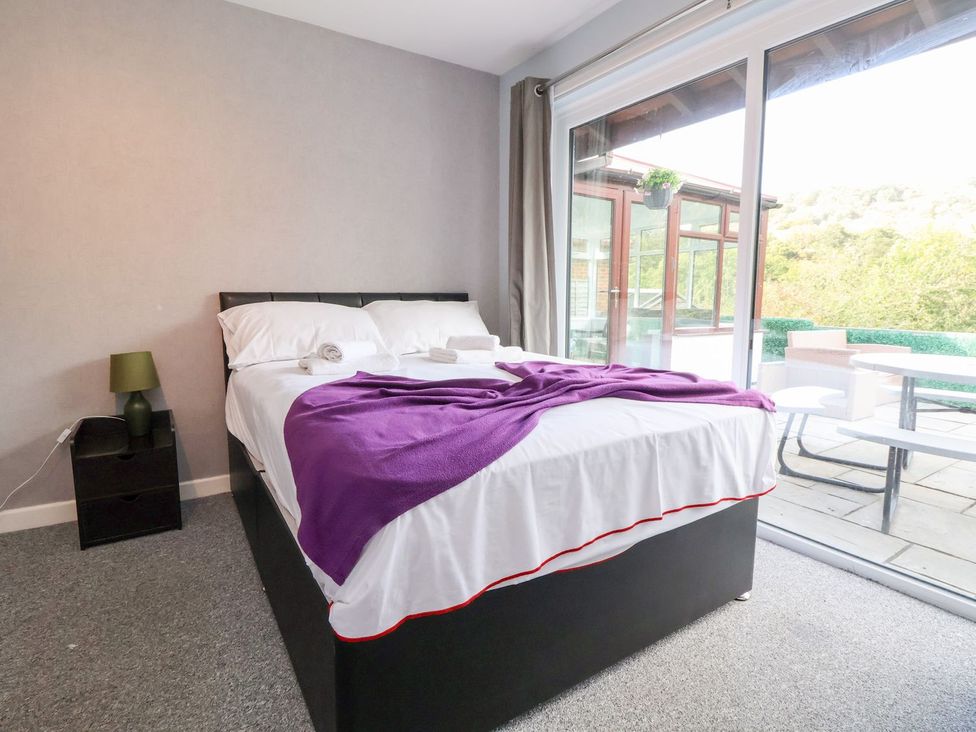 A bedroom with a bed and sliding door at Castellolwg 