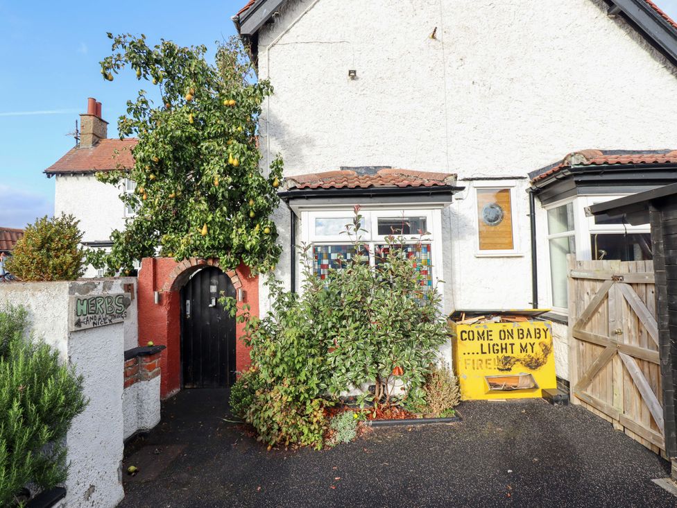 A front view of a house with a door and plants at Dormy Cottage in Skegness