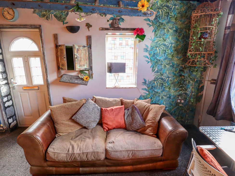 A living room with a sofa and window at Dormy Cottage in Skegness