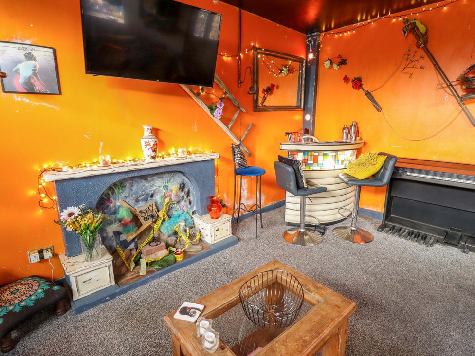 A snug with a television and bar at Dormy Cottage in Skegness