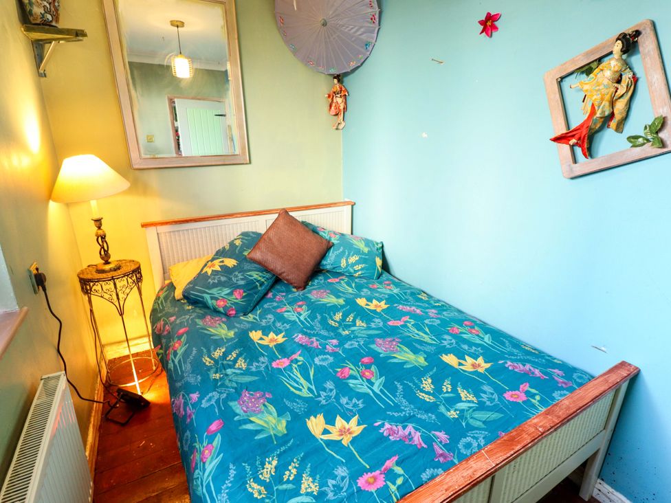 A bedroom with a bed and lamp at Dormy Cottage in Skegness