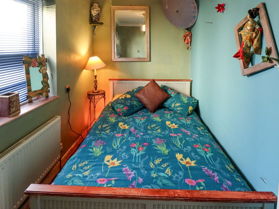 A bedroom with a bed and lamp at Dormy Cottage in Skegness