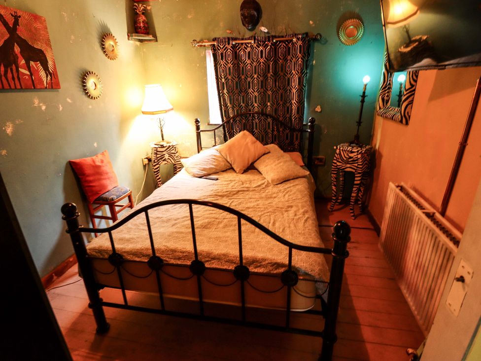 A bedroom with a bed and a lamp at Dormy Cottage in Skegness