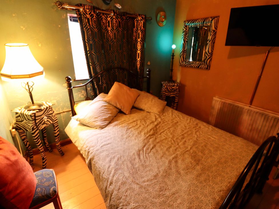 A bedroom with a bed and zebra print decor at Dormy Cottage in Skegness
