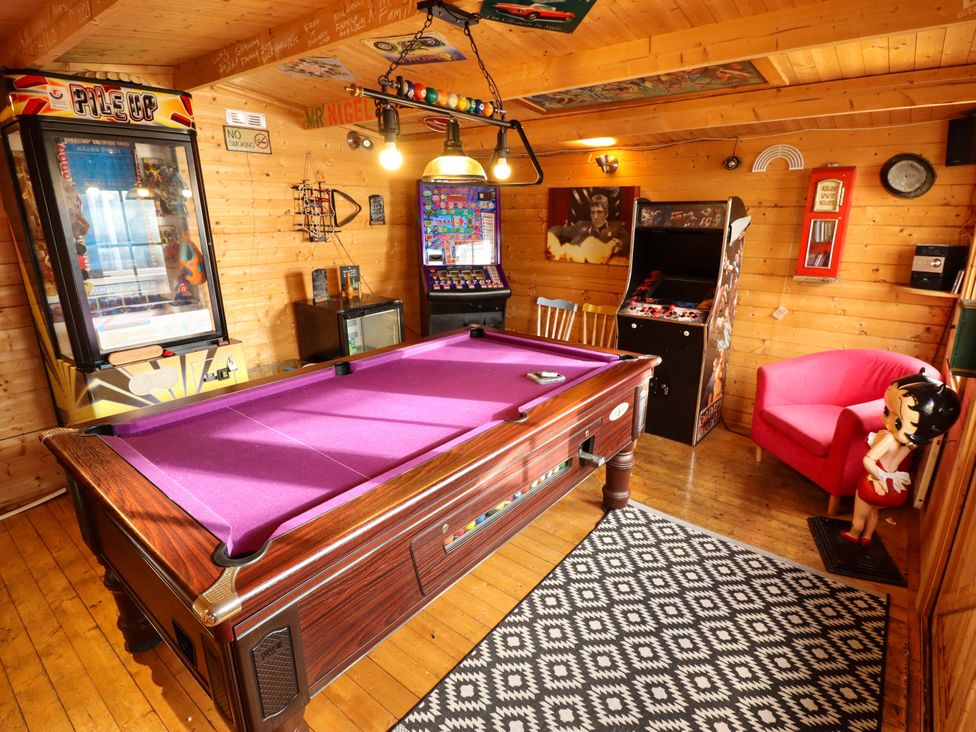 A game room with a pool table and arcade machines at Dormy Cottage in Skegness