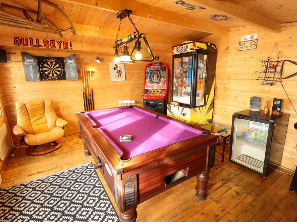 A game room with a pool table and slot machine at Dormy Cottage in Skegness