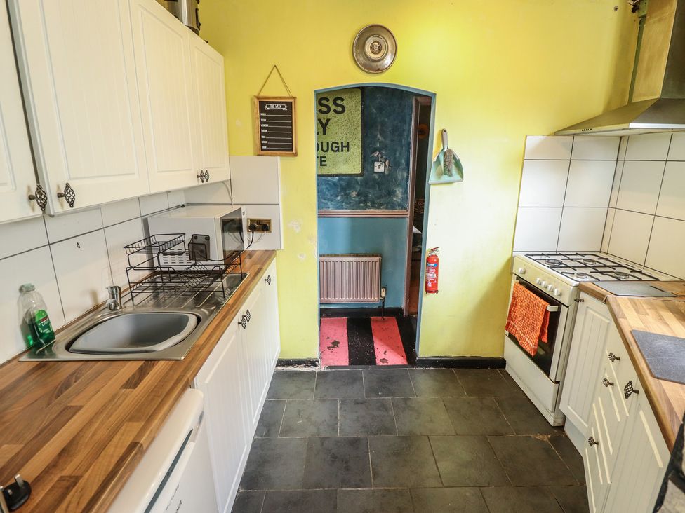A kitchen with a sink and microwave at Dormy Cottage in Skegness