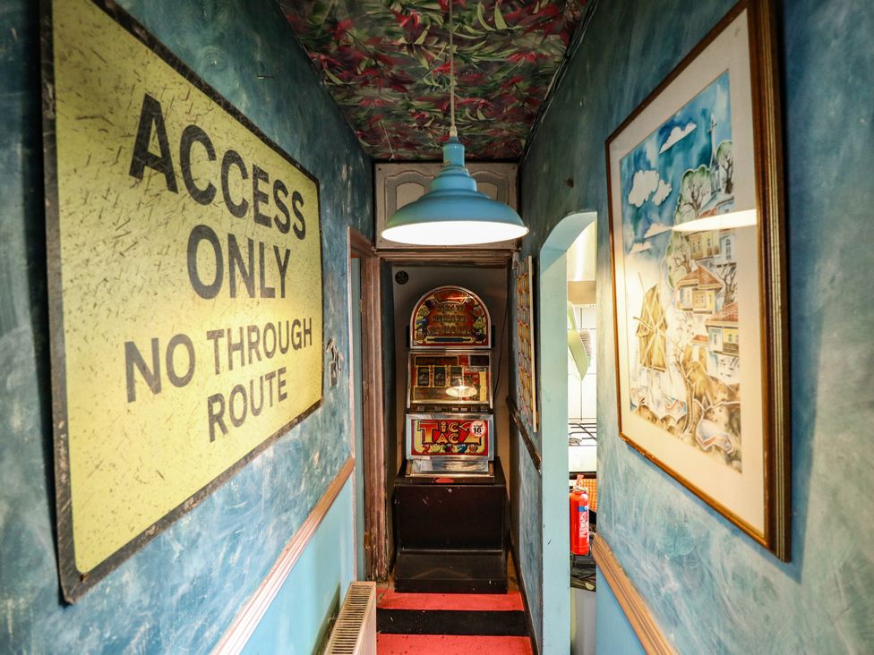 A hallway with a sign and arcade machine at Dormy Cottage in Skegness
