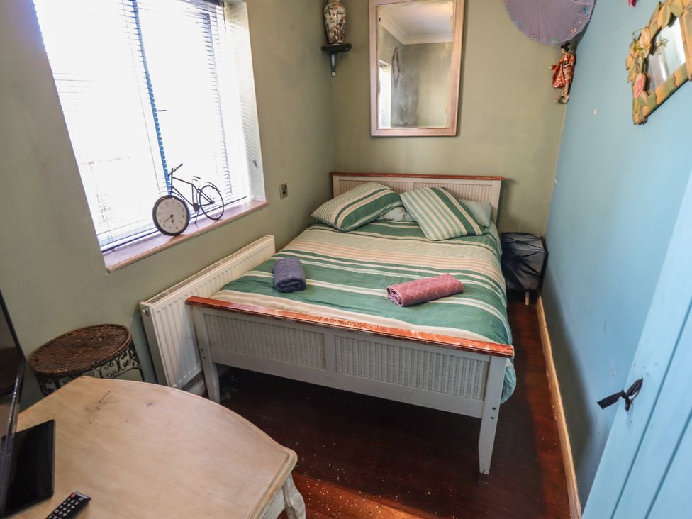 A bedroom with a bed and clock at Dormy Cottage Skegness