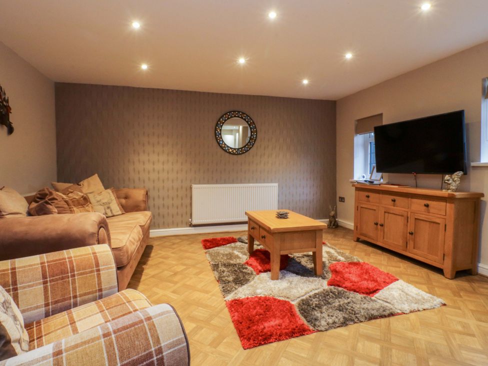 A living room with a coffee table and television at Mayfield Cottage in Blackpool