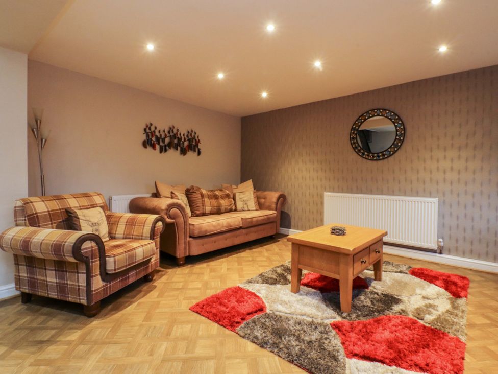 A living room with a coffee table and sofas at Mayfield Cottage in Blackpool
