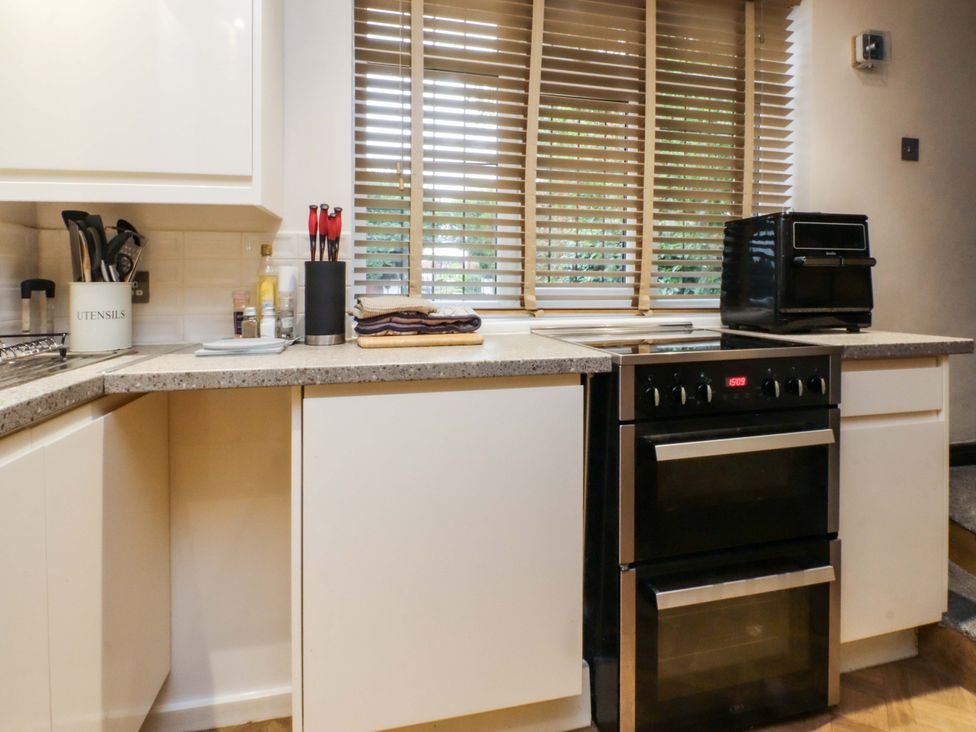 A kitchen with an oven and utensils on the countertop at Mayfield Cottage in Blackpool