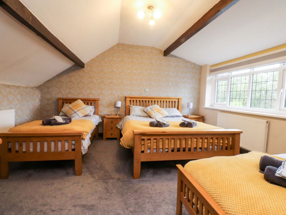 A bedroom with three beds and a window at Mayfield Cottage Blackpool