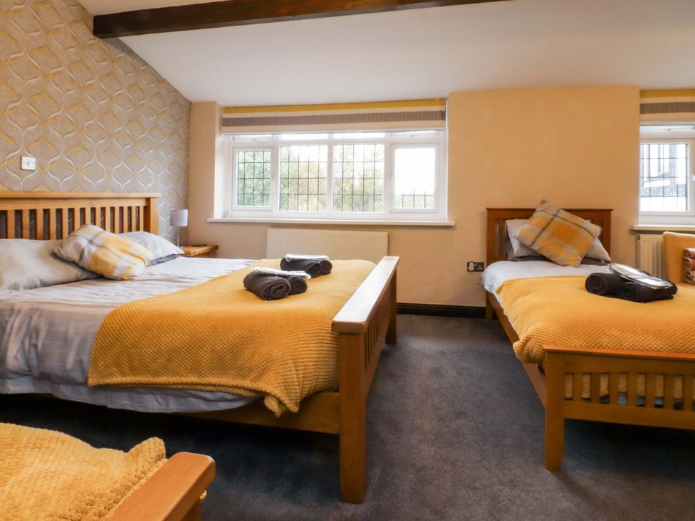 A bedroom with two beds and a window at Mayfield Cottage in Blackpool