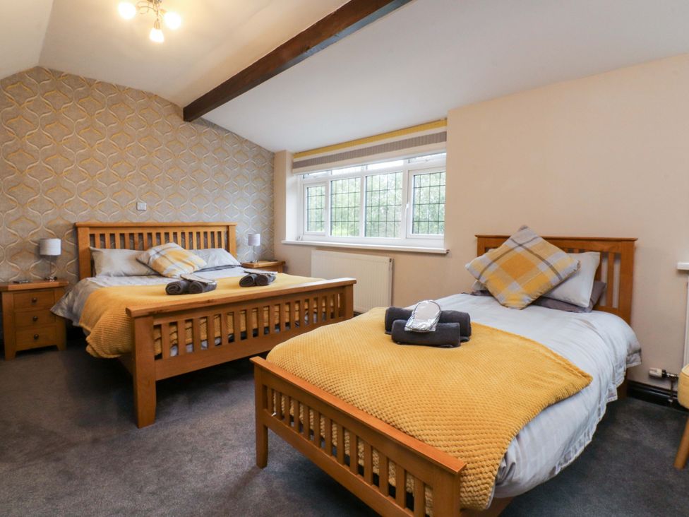 A bedroom with two beds and windows at Mayfield Cottage in Blackpool