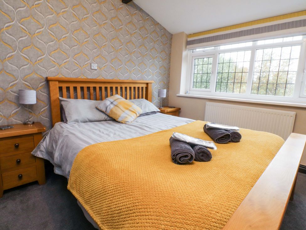 A bedroom with a bed and nightstands at Mayfield Cottage in Blackpool