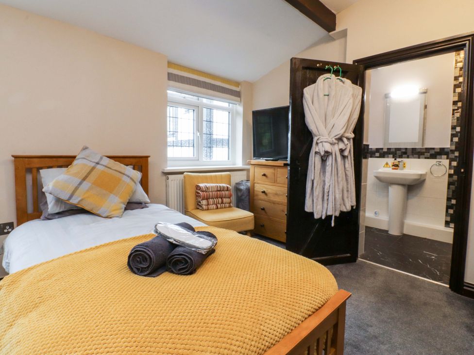A bedroom with bed and television at Mayfield Cottage in Blackpool