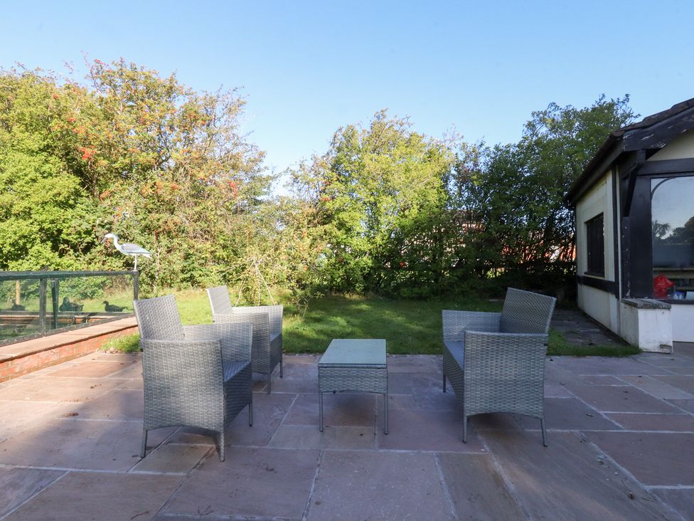 A patio with chairs and table at Mayfield Cottage in Blackpool