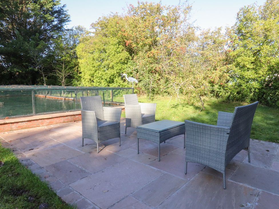 A garden with chairs and a table at Mayfield Cottage in Blackpool
