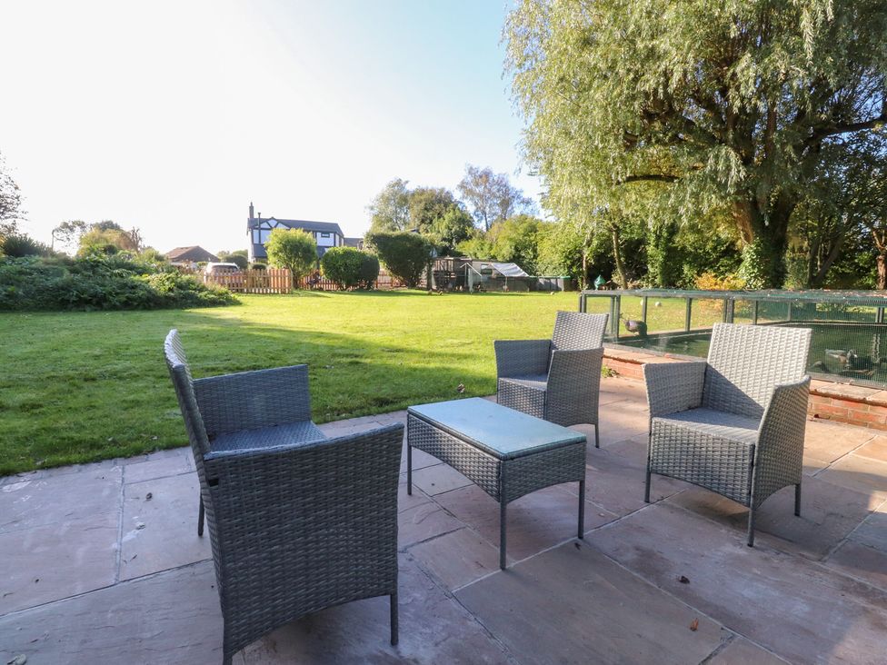 A garden with chairs and a table at Mayfield Cottage in Blackpool