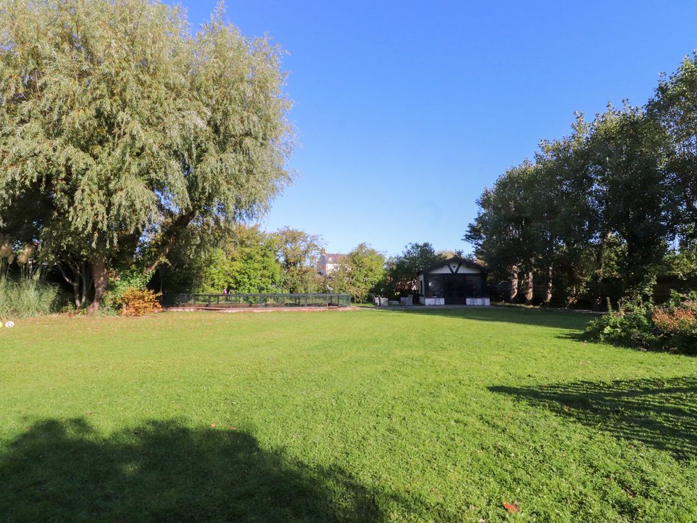 A garden with trees and a shed at Mayfield Cottage in Blackpool
