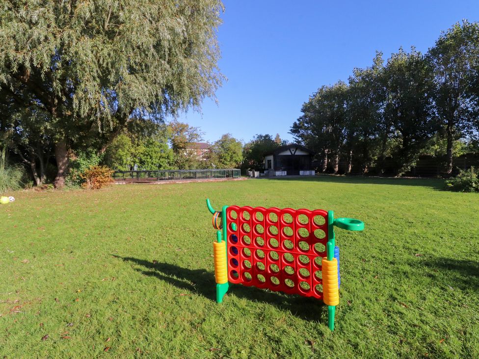 A garden with a playground game in the foreground at Mayfield Cottage in Blackpool