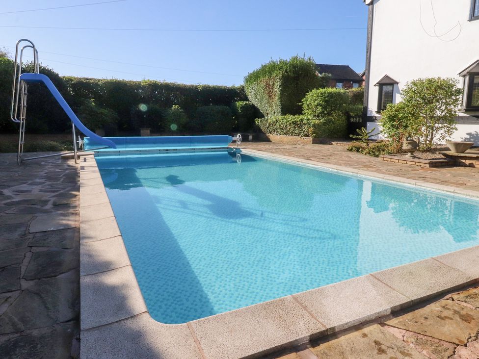 An outdoor area with a swimming pool and slide at Mayfield Cottage in Blackpool