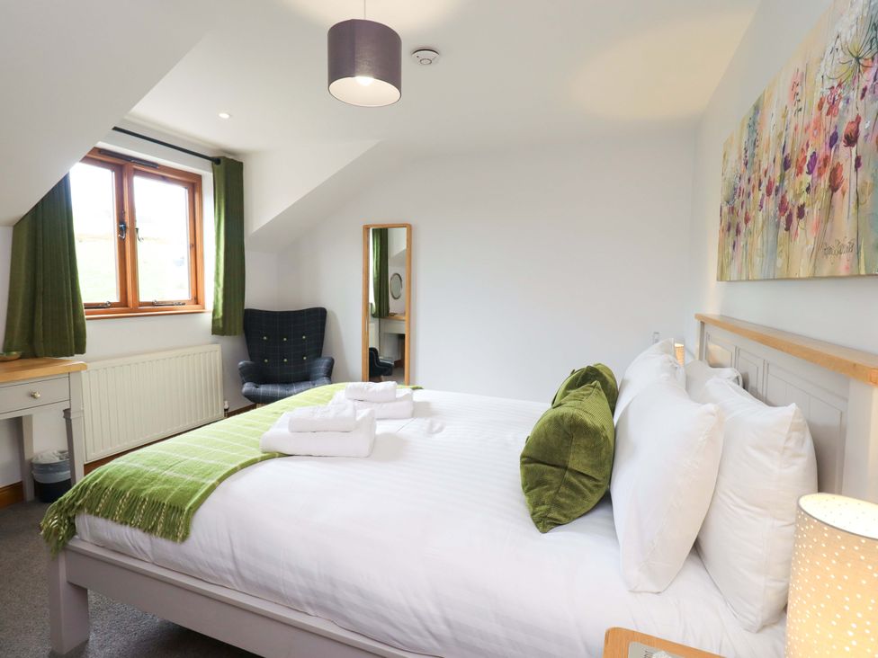 A bedroom with a bed and chair at High Dow Crag in Coniston
