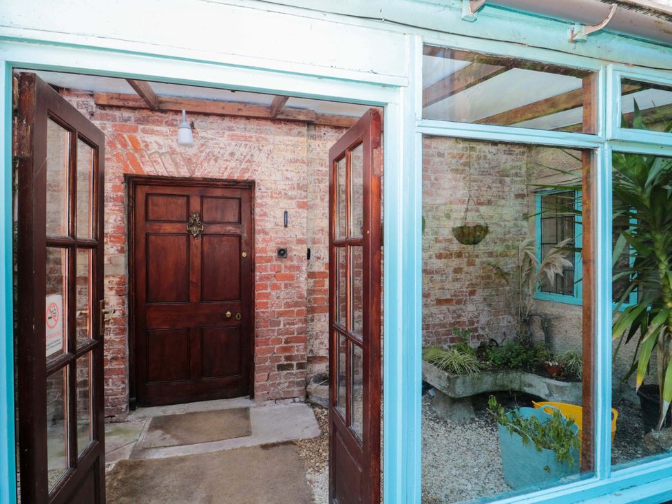 An entrance with a front door and plants at The West Wing