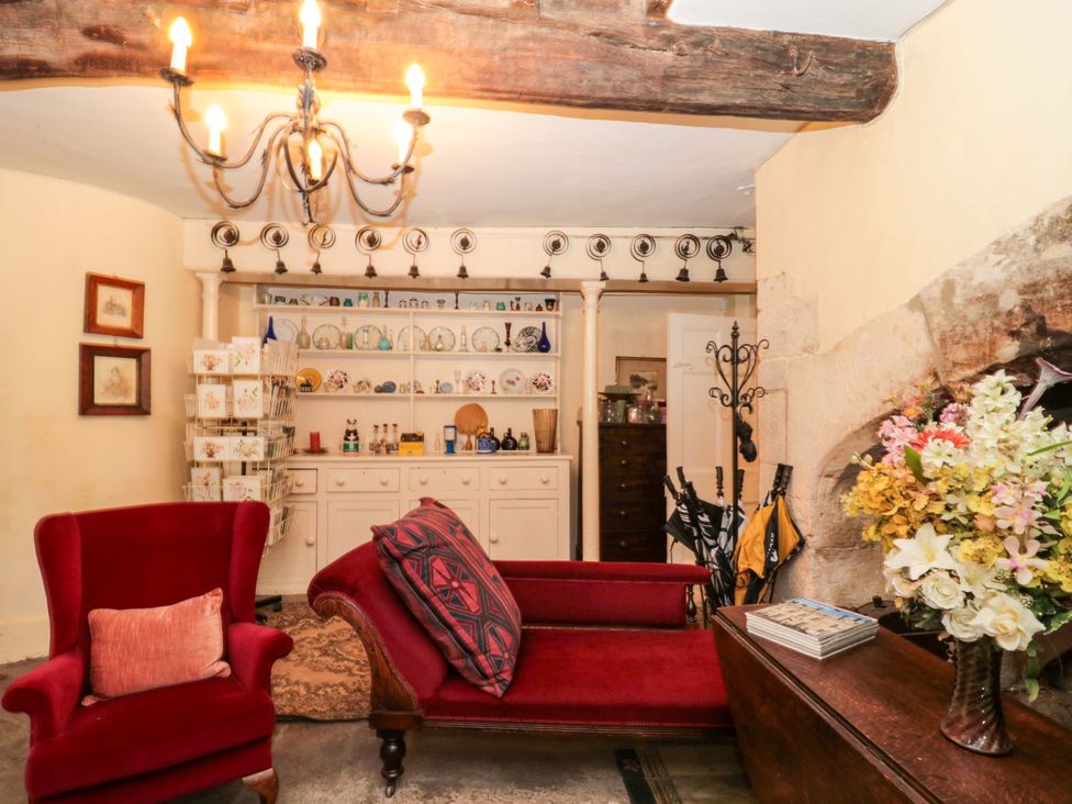 A living room with a chandelier and red furniture at The West Wing 