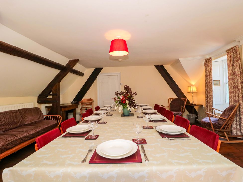 A dining room with a long table and chairs at The West Wing 