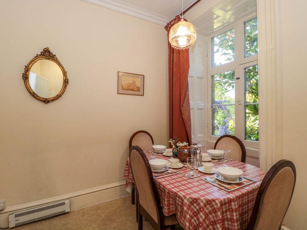 A dining room with a table set for meals at The West Wing 