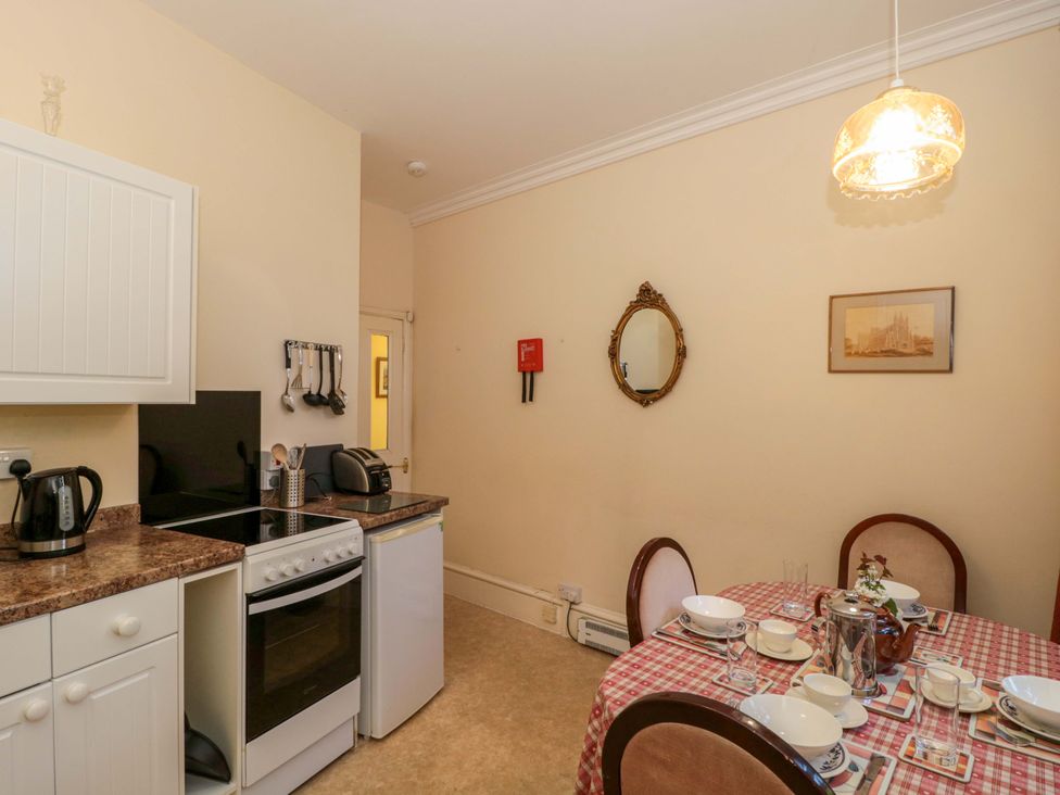 A kitchen with dining table and appliances at The West Wing 