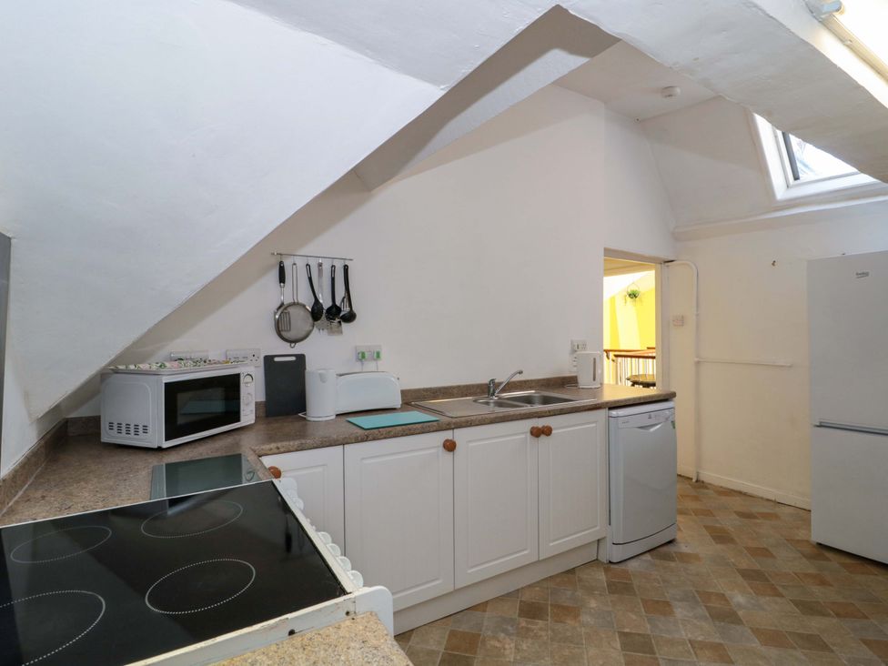 A kitchen with a sink, microwave, and stove at The West Wing