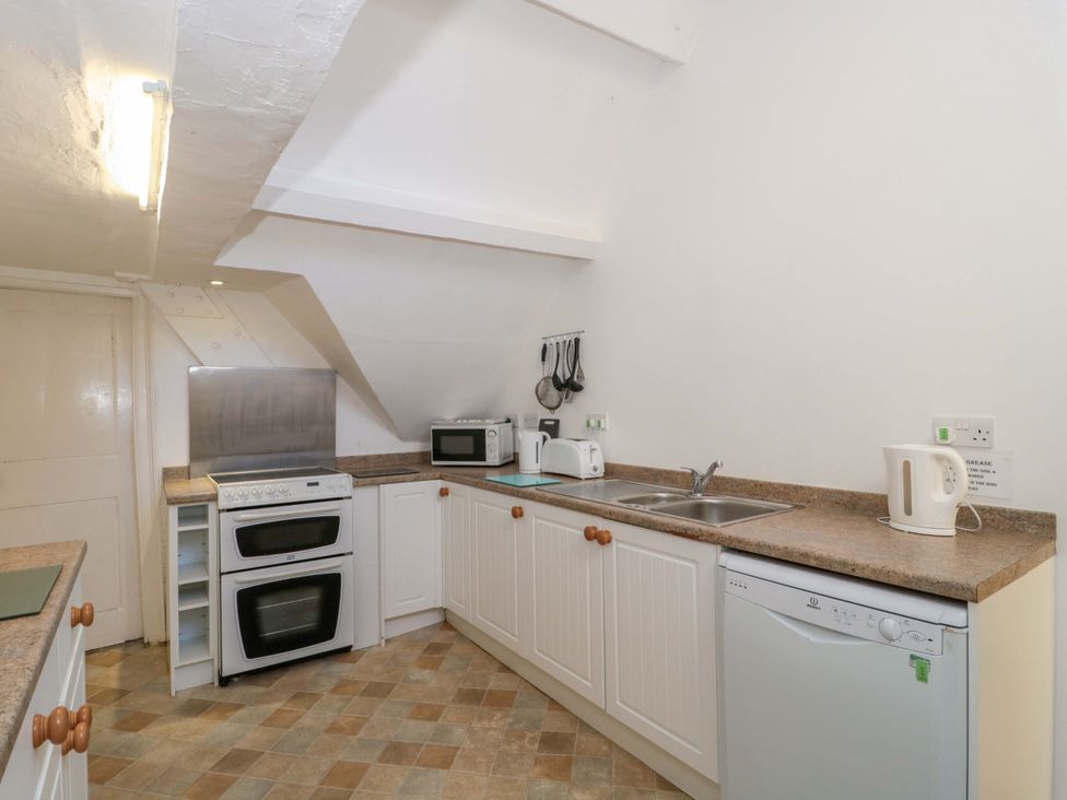 A kitchen with an oven, sink, and microwave at The West Wing 