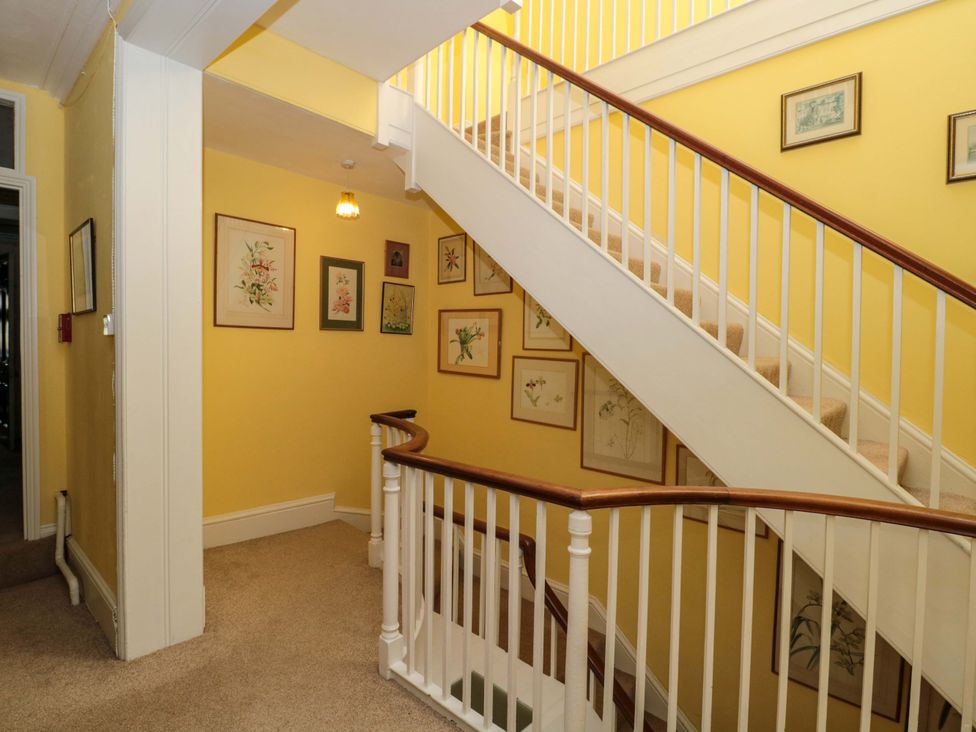 A staircase with pictures on the wall at The West Wing 