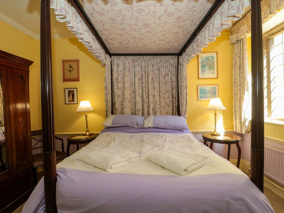 A bedroom with a canopy bed and lamp at The West Wing