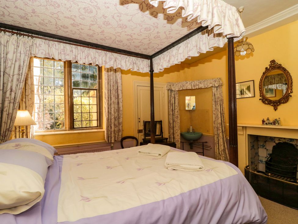A bedroom with a canopy bed and a fireplace at The West Wing 
