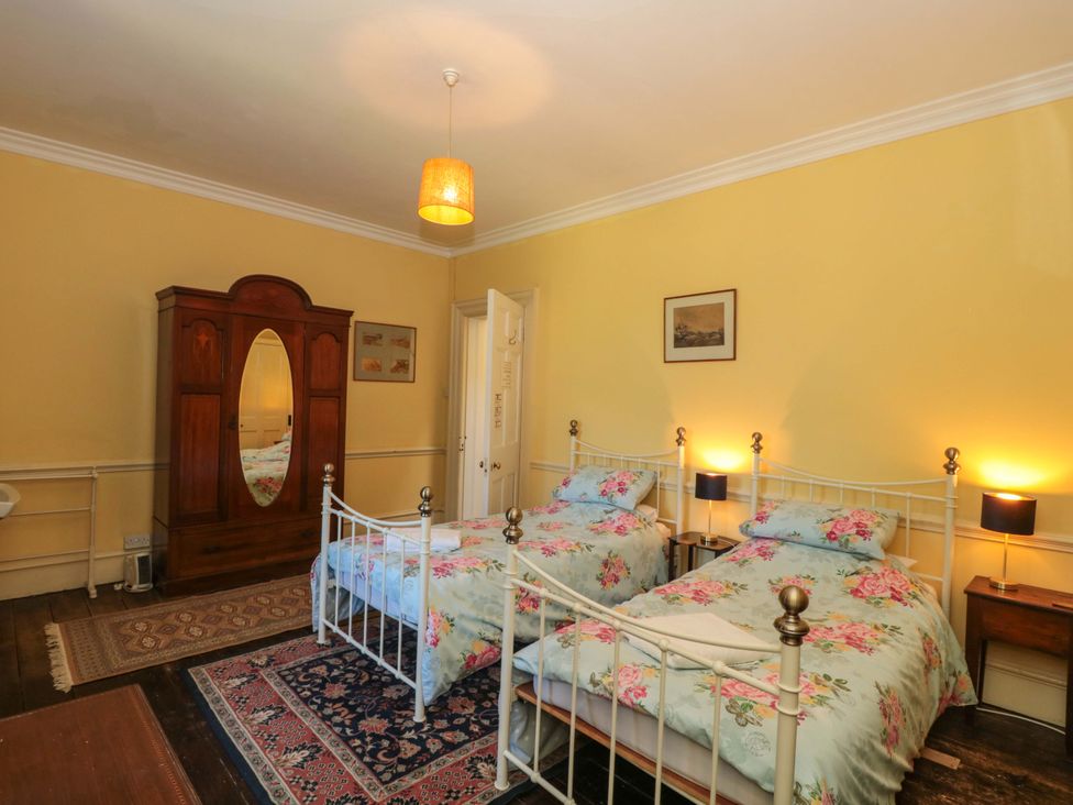 A bedroom with two beds and a wardrobe at The West Wing 